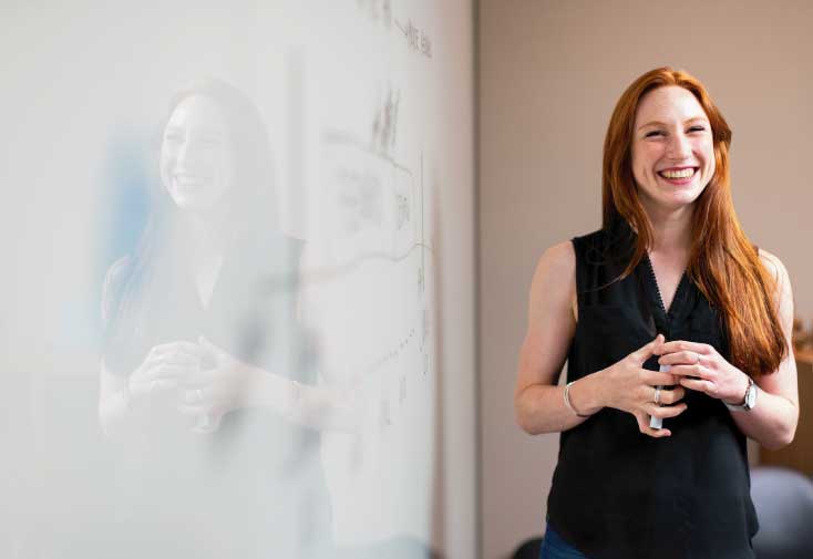 female teacher standing by whiteboard