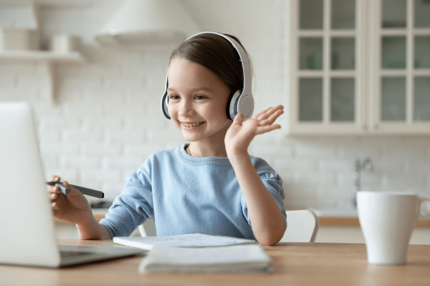 smiling young girl wearing headset working at laptop